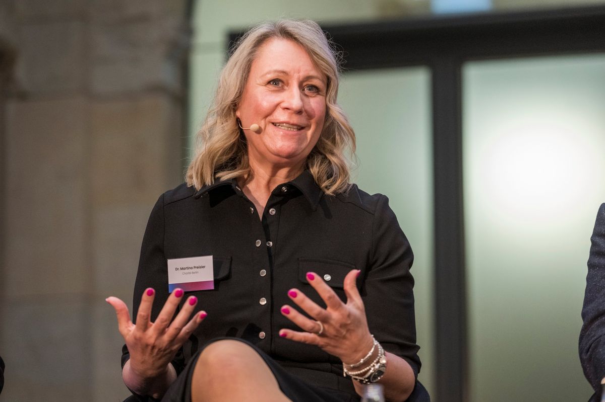 Martina Preisler im Gespräch auf einem Podium, lachend und gestikulierend
